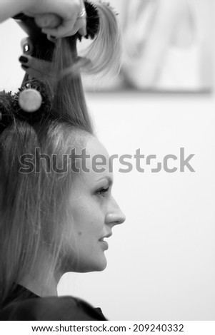 Profile o beautiful woman changing her hairstyle in salon, monochrome