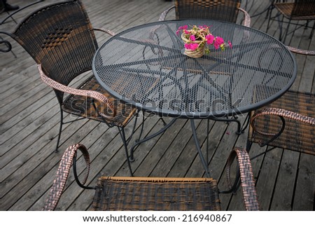 Open-air cafe furniture, wicker chairs and metallic table