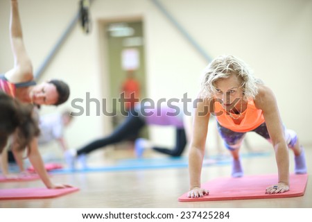 Mature woman doing push-up on padded mat
