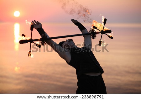 Fire dance element, man performing with fire staffs