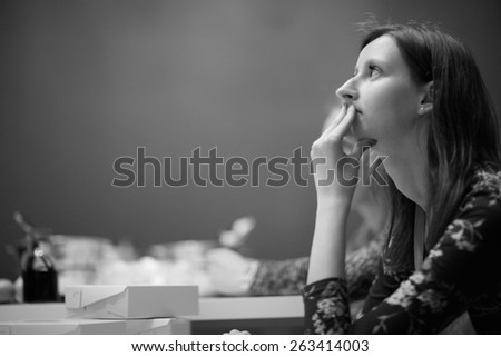 Profile of young woman with hand covering mouth