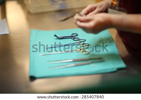 Health care worker examining surgical clamps