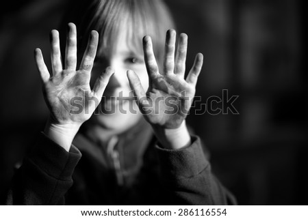 Happy child showing his dirty hands, focus on hands