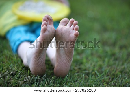 Dirty feet of a child sitting on the grass
