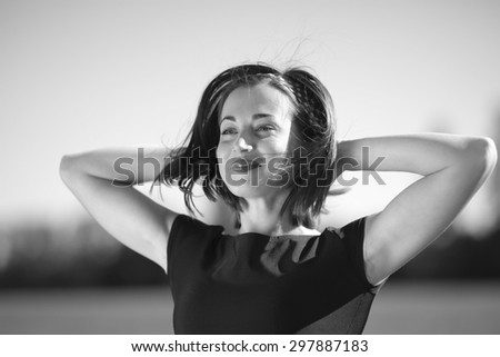 Beautiful encouraged lady looking forward with hands behind the head