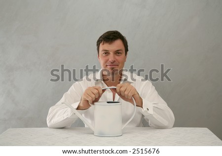Man sitting and smiling with water-pot in his hands