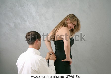 man helping woman get dressed
