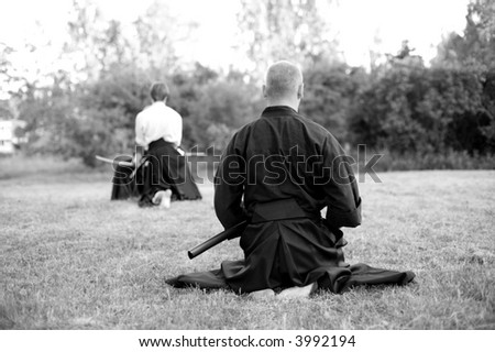 men practicing martial arts outdoors - black and white