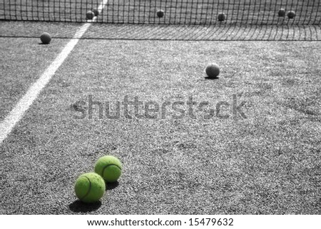 Two yellow tennis balls on black and white court background
