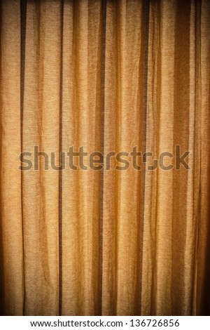 Close-up view of bright blue curtain in thin and thick vertical folds made of dense fabric. Textured abstract backgrounds and wallpapers. Materials and textiles.