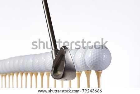 Golf balls lined up and ready to hit with a golf club