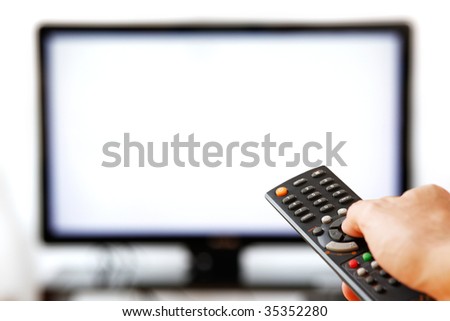 Out of focus TV LCD set and remote control in man\'s hand isolated over a white background. Blank screen.