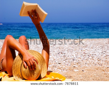 Pretty girl reading novel at beautiful beach