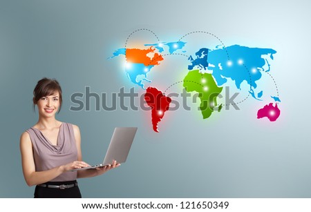 Beautiful young woman holding a laptop and presenting colorful world map