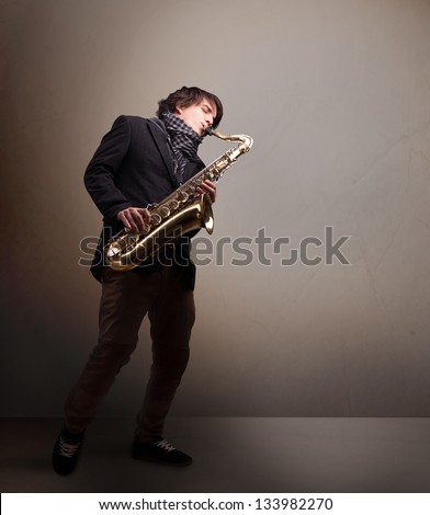 Handsome young musician playing on saxophone