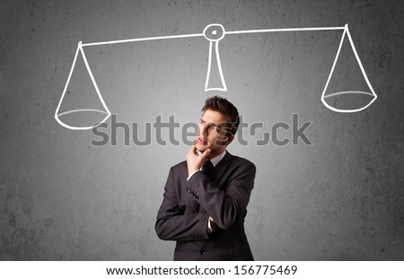 Young businessman taking a decision with scale above his head