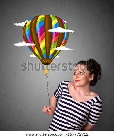 Young woman holding a balloon drawing with clouds