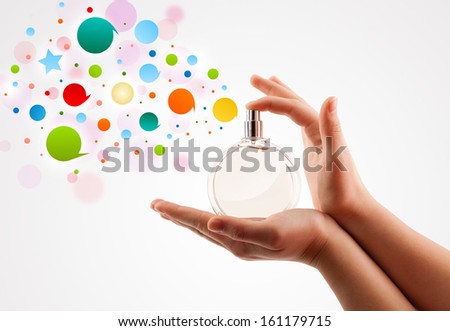 close up of woman hands spraying colorful bubbles from beautiful perfume bottle