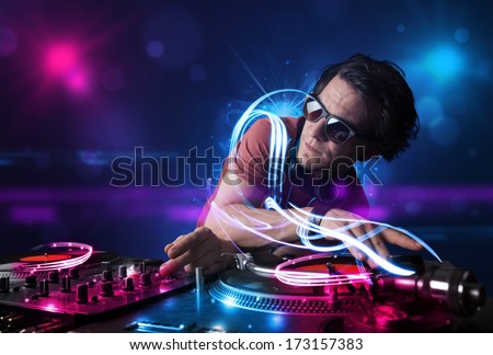 Young disc jockey playing music with electro light effects and lights