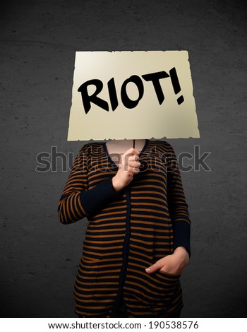 Young woman holding a demonstration board with riot sign in front of her head