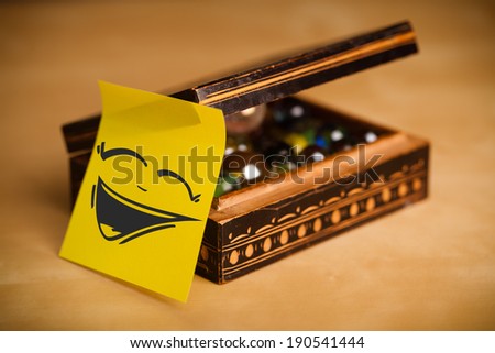 Drawn smiley face on a post-it note sticked on jewelry box