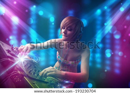 Pretty Dj mixing music in a club with blue and purple lights