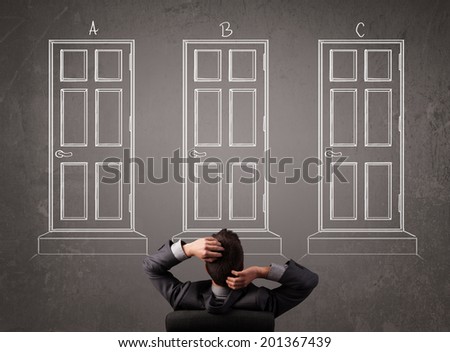 Young businessman sitting in front of a chalkboard and trying to choose the right door