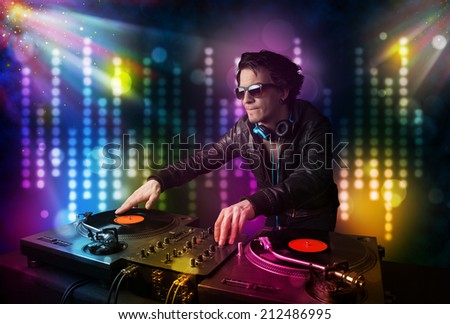 Young Dj playing songs in a disco with light show