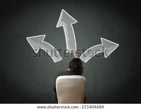 Young businessman sitting and making a decision in an office chair with different directed arrows above his head
