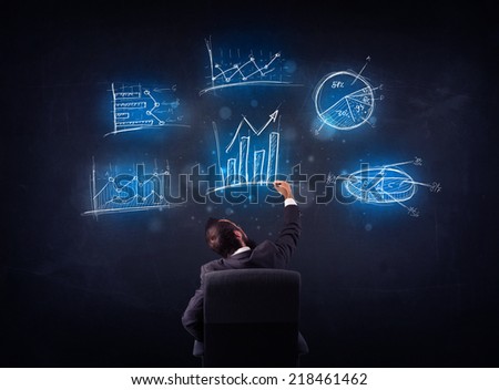 Young businessman sitting in office chair with glowing charts above his head