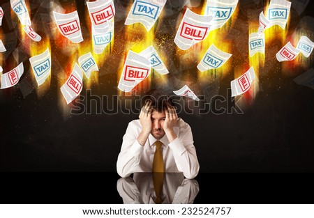 Depressed businessman sitting under falling papers