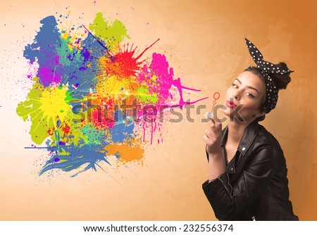 Cute girl blowing bubble spalsh graffiti into wall