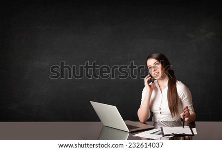 Businesswoman sitting at black table with a laptop on black background