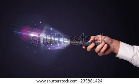 Hand holding a remote control, shining numbers and letters coming out of it