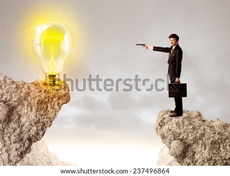 Businessman standing on the edge of mountain with an idea bulb on the other side