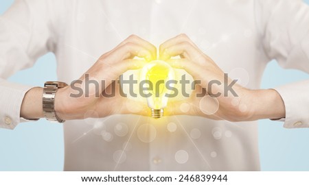 Hands creating a form with yellow light bulb in the center