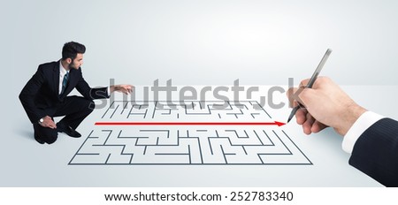 Business man looking at hand drawing solution for maze solution concept