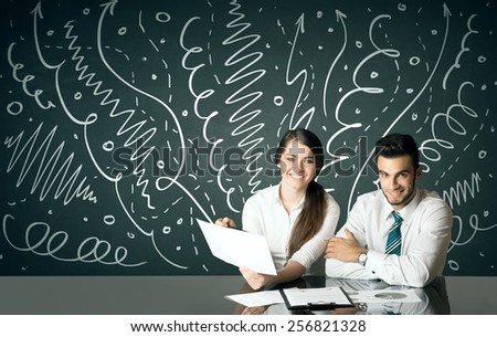 Business couple sitting at table with drawn curly lines and arrows on the background