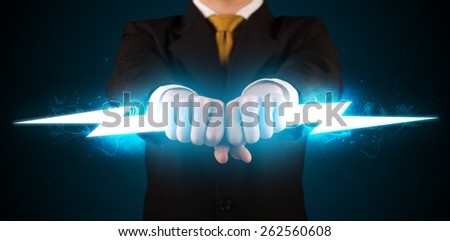 Business man holding glowing lightning bolt in his hands concept