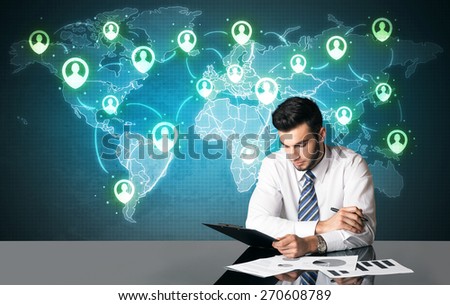Businessman sitting at table with social media connection symbols on the world map