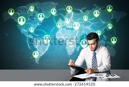 Businessman sitting at table with social media connection symbols on the world map