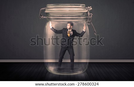 Businessman trapped into a glass jar concept on background