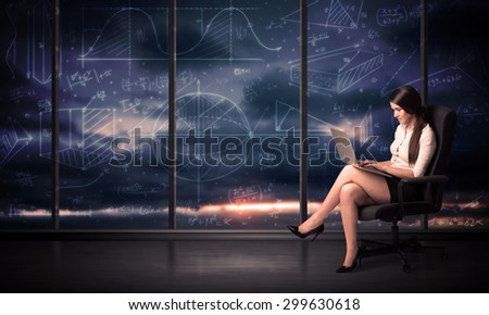 Businesswoman holding laptop in office room with graph charts on window concept
