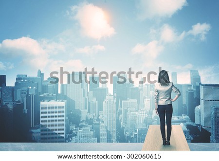 Businesswoman standing on a roof and looking at future city