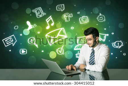 Businessman sitting at the black table with social media symbols on the background