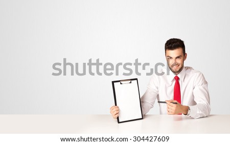 Business man sitting at white table with a white empty folder on white background