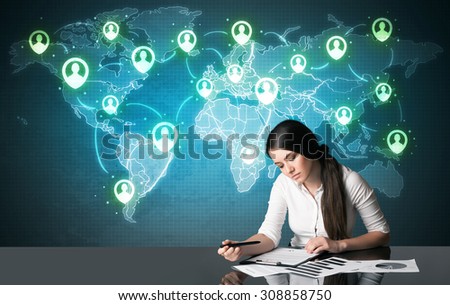 Businesswoman sitting at table with social media connection symbols on the world map