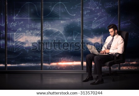 Businessman holding laptop in office room with graph charts on window concept