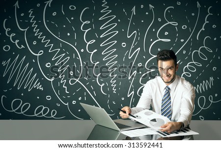Businessman sitting at table with drawn curly lines and arrows on the background