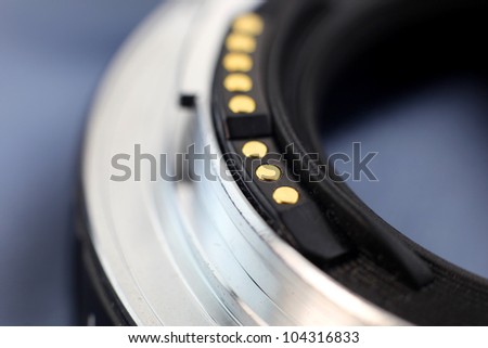 Macro shot of golden electrical contacts on camera lens